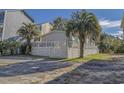 Single-story home with gray siding, teal accents, deck, and tropical landscaping at 6001 - Mh23 S Kings Hwy., Myrtle Beach, SC 29575