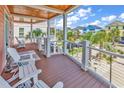 Spacious covered porch with white chairs and wooden floors at 310 A Ocean Blvd. N, Surfside Beach, SC 29575