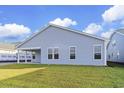Rear view of light blue house featuring covered patio and backyard at 1958 Woodrush Loop, Little River, SC 29566