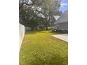 Large grassy side yard with white fence and mature trees at 410 40Th Ave. N, Myrtle Beach, SC 29577