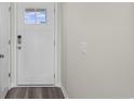 Front entry with white door, keyless entry, and wood-look flooring at 3058 Deerberry Place, Longs, SC 29568