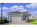 One-story house with light blue siding, white garage door, and landscaped front yard at 3058 Deerberry Place, Longs, SC 29568