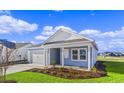 Newly built home with light blue siding, white accents, and a neatly landscaped yard at 3058 Deerberry Place, Longs, SC 29568
