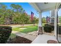 Inviting front porch with stone accents and American flags, showcasing curb appeal at 444 Papyrus Circle # 444, Little River, SC 29566