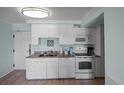 White kitchen cabinets, granite countertops, and stainless steel appliances at 14290 Ocean Hwy. # 208, Pawleys Island, SC 29585