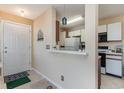 Galley kitchen with white cabinets and view into adjacent living area at 8862 Cloister Dr. # F, Myrtle Beach, SC 29575