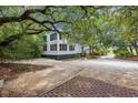 White two-story home with a gravel driveway and lush landscaping at 496 Myrtle Ave., Pawleys Island, SC 29585