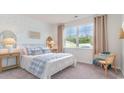 Cozy bedroom with light blue and white bedding, a large window, and a patterned wallpaper accent at 201 Hadley Springs Ave, Longs, SC 29568