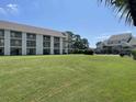 Multi-unit building with grassy lawn at 1025 Plantation Dr. W # 3421, Little River, SC 29566