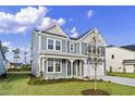 Two-story house with gray siding, white trim, landscaping, and a two-car garage at 1019 Gold Dew Way, Myrtle Beach, SC 29579