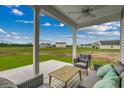 Relaxing covered patio with seating area, overlooking a grassy yard at 727 Night Lotus Dr., Calabash, NC 28467