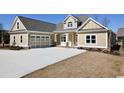 Two-story house with beige siding, gray roof, and a large three-car garage at 1100 Maccoa Dr., Conway, SC 29526