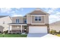 Two-story house with beige siding, stone accents, and a two-car garage at 357 Glacier Way, Conway, SC 29526