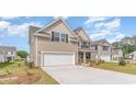 Two-story home with beige siding, white garage door, and stone accents at 828 Hibernation Way, Conway, SC 29526