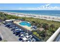 Aerial view of a condo pool, parking lot, and beach at 9820 Queensway Blvd. # 507, Myrtle Beach, SC 29572