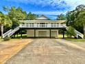 Two-story house, elevated, with a double garage and walkway at 6005 Saint Peters Church Rd., Myrtle Beach, SC 29588