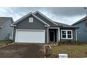 Gray house with white garage door and landscaping at 1336 Winding Creek Way, Myrtle Beach, SC 29588