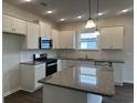 Modern kitchen with white cabinets, granite countertops, and stainless steel appliances at 1348 Winding Creek Way, Myrtle Beach, SC 29588