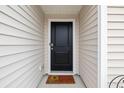 Black front door with a welcome mat at 805 Woodland Farms Circle, Aynor, SC 29511