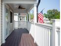 Relaxing front porch with a ceiling fan and American flag at 1517 Schooner Ct., Garden City Beach, SC 29576