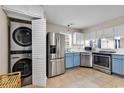 Modern kitchen with stainless steel appliances and blue cabinets, stackable washer/dryer at 4255 Villas Dr. # 201, Little River, SC 29566