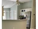 View of kitchen with stainless steel refrigerator and white cabinets at 176 King George Rd., Georgetown, SC 29440