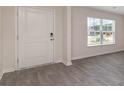 Bright entryway with neutral gray vinyl plank flooring and white door at 831 Buttonwood Dr., Conway, SC 29527