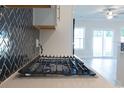 Modern gas cooktop in a kitchen with white cabinets and a herringbone backsplash at Tbb1 Shady Grove Rd., Conway, SC 29527