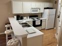 Bright kitchen with white cabinets, breakfast bar, and stainless steel appliances at 616 River Oaks Dr. # 54F, Myrtle Beach, SC 29579