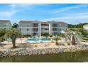 Community pool with surrounding patio and waterfront views at 1960 C Bent Grass Dr. # C, Surfside Beach, SC 29575