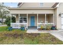 Front porch with rocking chairs, planters, and blue door at 1356 Tranquility Ln., Myrtle Beach, SC 29577