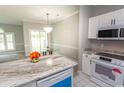 White cabinets, granite countertops, and stainless steel appliances in this kitchen at 682 Riverwalk Dr. # 102, Myrtle Beach, SC 29579