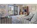 Living room with comfy sofas, balcony access, and coastal decor at 5905 S Kings Highway # 219-B, Myrtle Beach, SC 29575