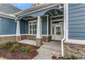 Inviting front porch with stone columns and white door at 1104 Maccoa Dr., Conway, SC 29526