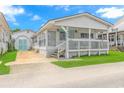 White beach cottage with a covered porch and green lawn at 6001-1424 S Kings Hwy., Myrtle Beach, SC 29575