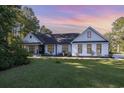 Modern farmhouse style home with white siding, black accents, and a nicely landscaped lawn at 1886 Southwood Dr., Myrtle Beach, SC 29575