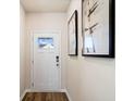Bright entryway with white door, wood floor, and modern wall art at 3042 Deerberry Place, Longs, SC 29568