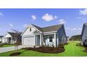 Newly built home with light blue siding, two-car garage, and a well-manicured lawn at 3042 Deerberry Place, Longs, SC 29568