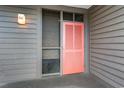 Inviting condo entry with coral door and screened window at 207 N Ocean Blvd. # 241, North Myrtle Beach, SC 29582