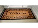 A coir welcome mat with a black border and the word 