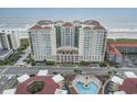 Aerial view of luxurious beachfront condo building with pool and ocean views at 603 S Ocean Blvd. # 1016, North Myrtle Beach, SC 29582