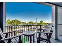 Balcony with two chairs and a table overlooking a pool and parking area at 5905 S Kings Hwy. # A-219, Myrtle Beach, SC 29575