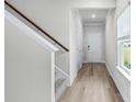 Hallway with stairs leading upstairs and light hardwood floors at 3539 Rayner Cove Ct., Little River, SC 29566