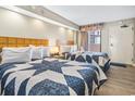 Two double beds in a condo bedroom with ocean view art at 1501 Ocean Blvd. S # 1140, Myrtle Beach, SC 29577