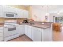 Kitchen with white cabinets, appliances, and a breakfast bar at 1100 Commons Blvd. # 107, Myrtle Beach, SC 29572