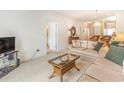 Living room with beige couch, glass table, and view of hallway and kitchen at 1100 Commons Blvd. # 107, Myrtle Beach, SC 29572