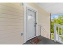 Front entrance of a condo unit with a white door and a welcome mat at 4191 Hibiscus Dr. # 304, Little River, SC 29566