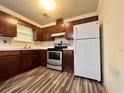 Simple kitchen with wood cabinets, laminate flooring, and stainless steel appliances at 3285 Della Rd., Longs, SC 29568