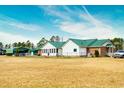 Brick ranch home with green metal roof, detached garage, and large yard at 1342 Highway 90, Conway, SC 29526