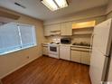 Galley kitchen with white appliances and wood floors at 1210 Pinegrove Dr. # G, Myrtle Beach, SC 29577